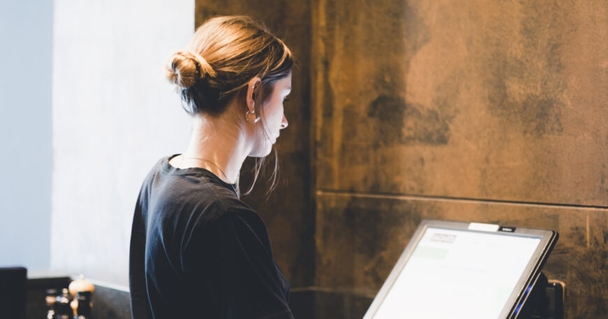 Young Hostess Standing Near Cash Register